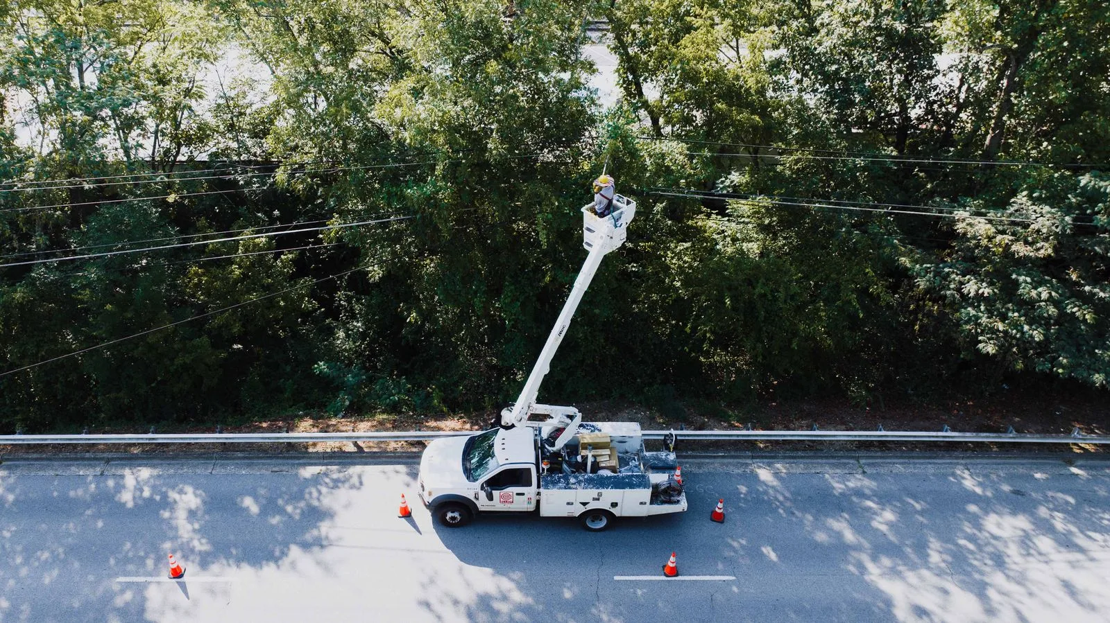 Utility lineworker on a bucket truck repairing overhead power lines