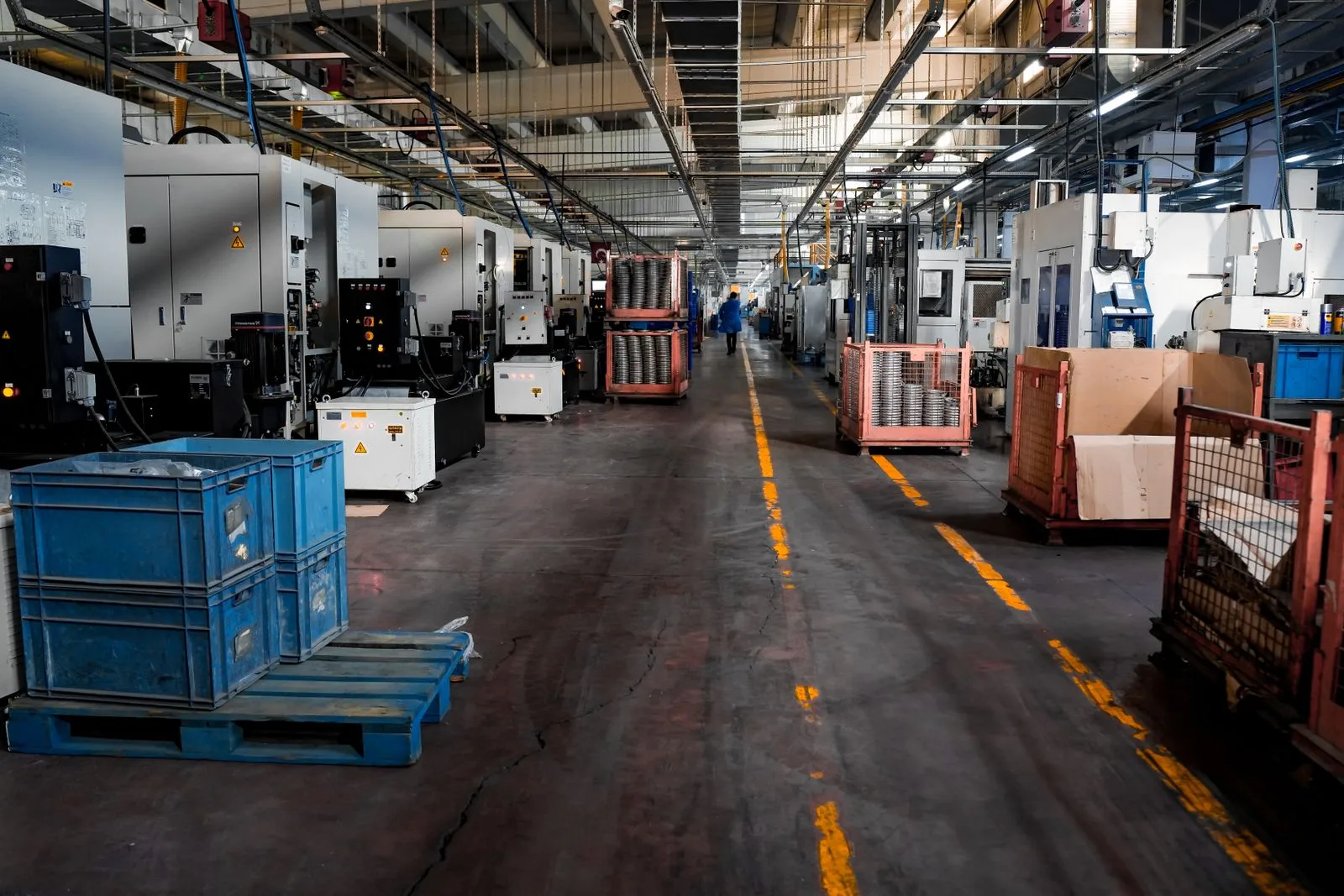 Wide view of an industrial factory floor with machinery and crates