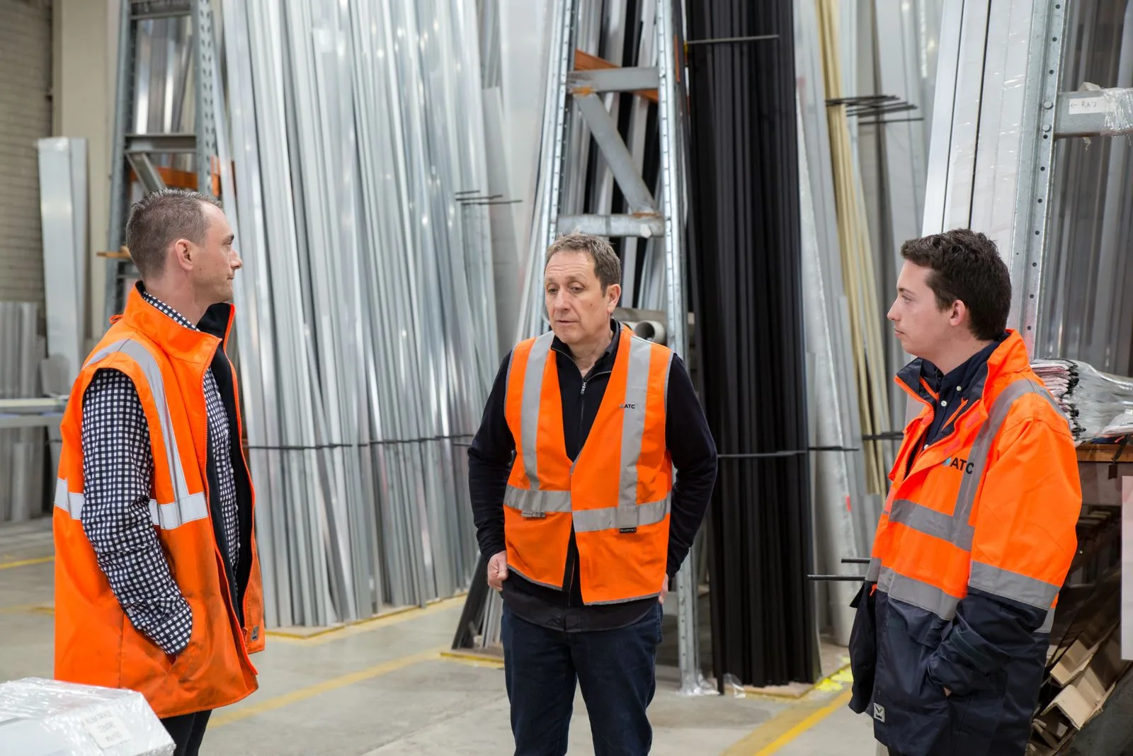 Warehouse team in safety gear discussing the day's work