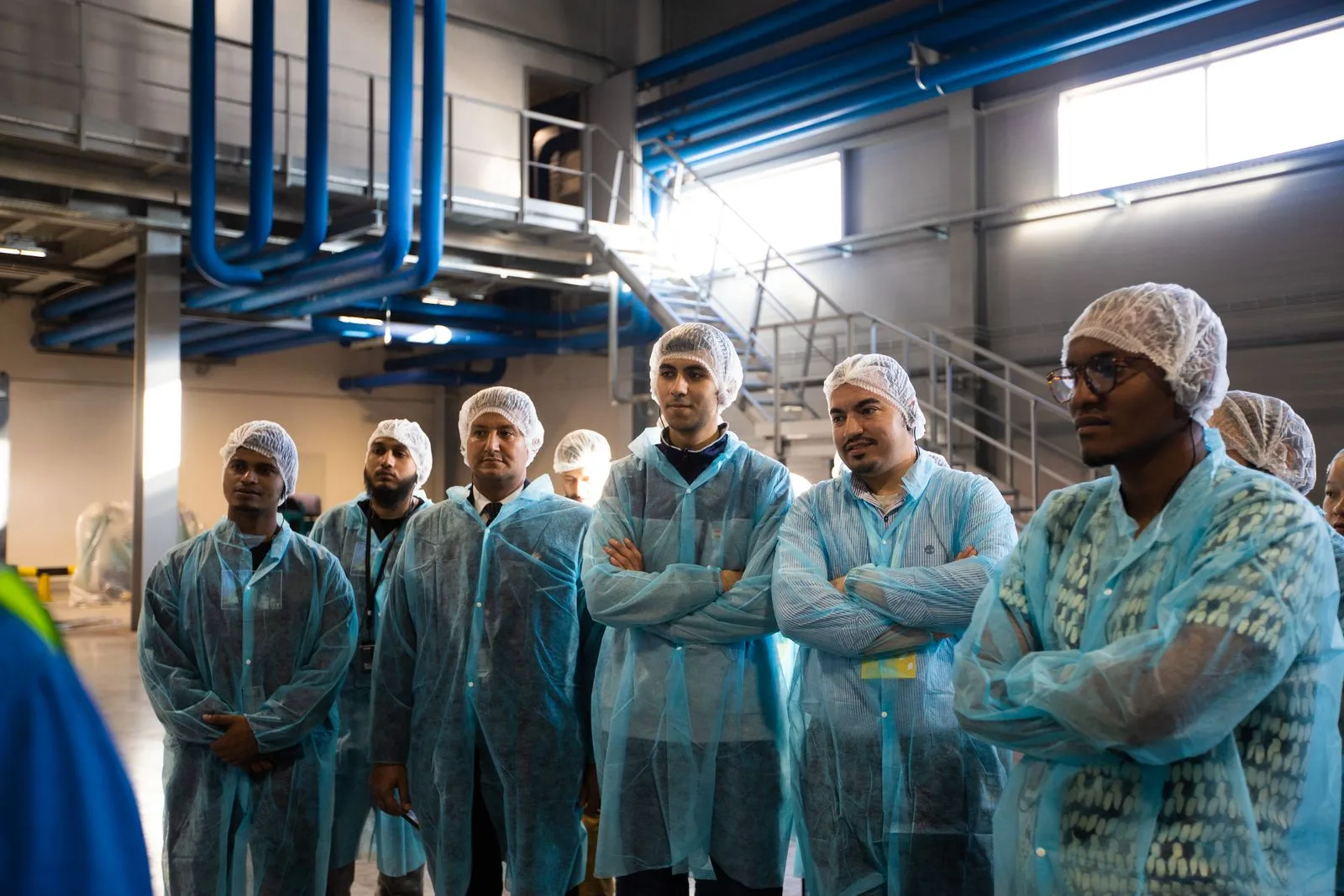 Workers standing together in a factory hall discussing a project