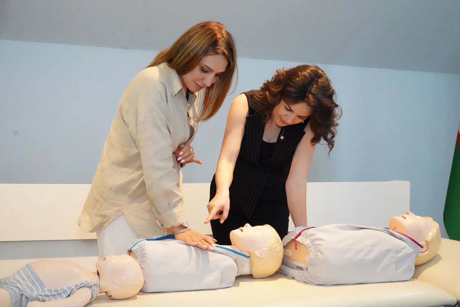 Two women practicing CPR on training mannequins