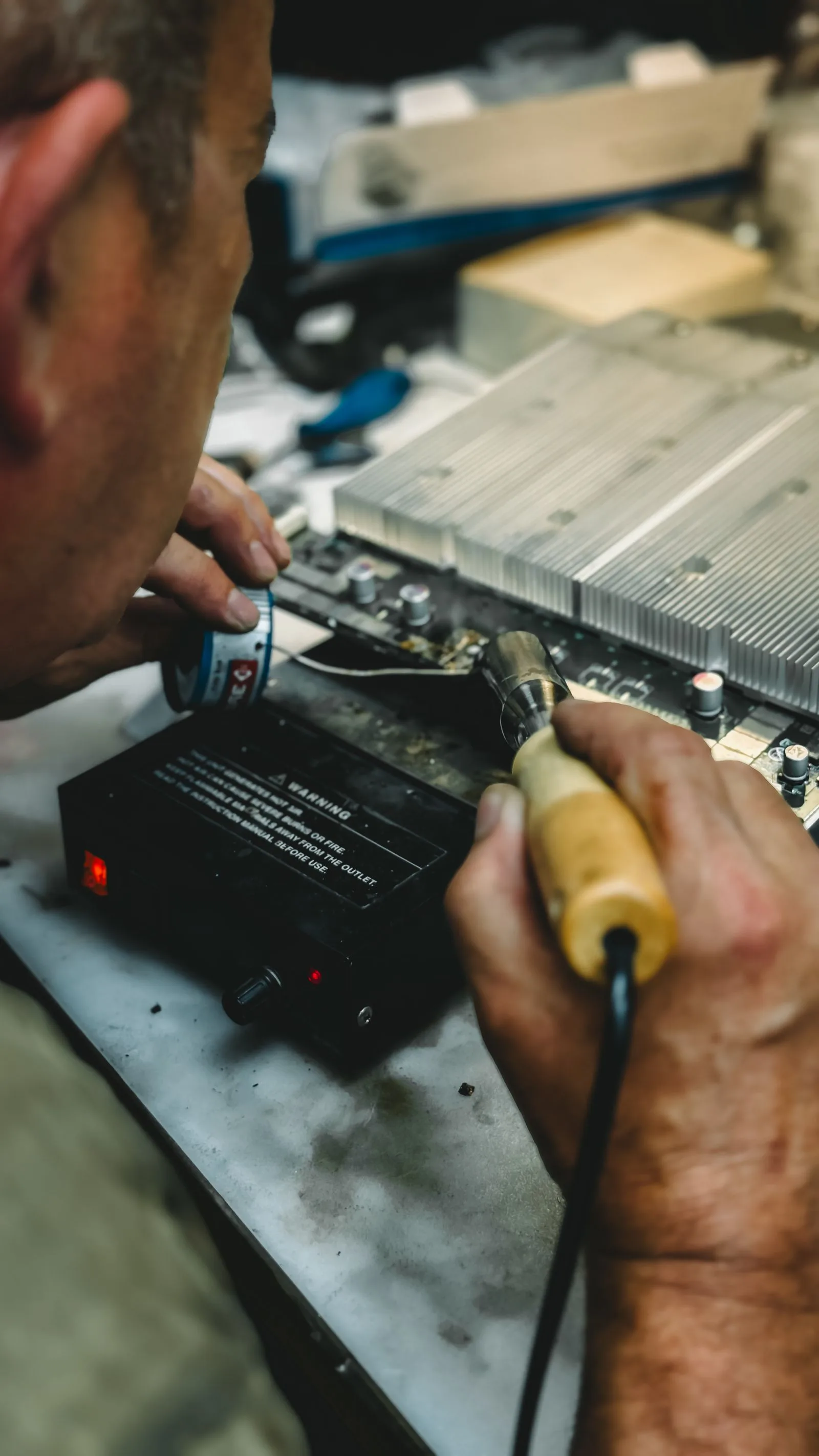 Close-up of a technician soldering a circuit board