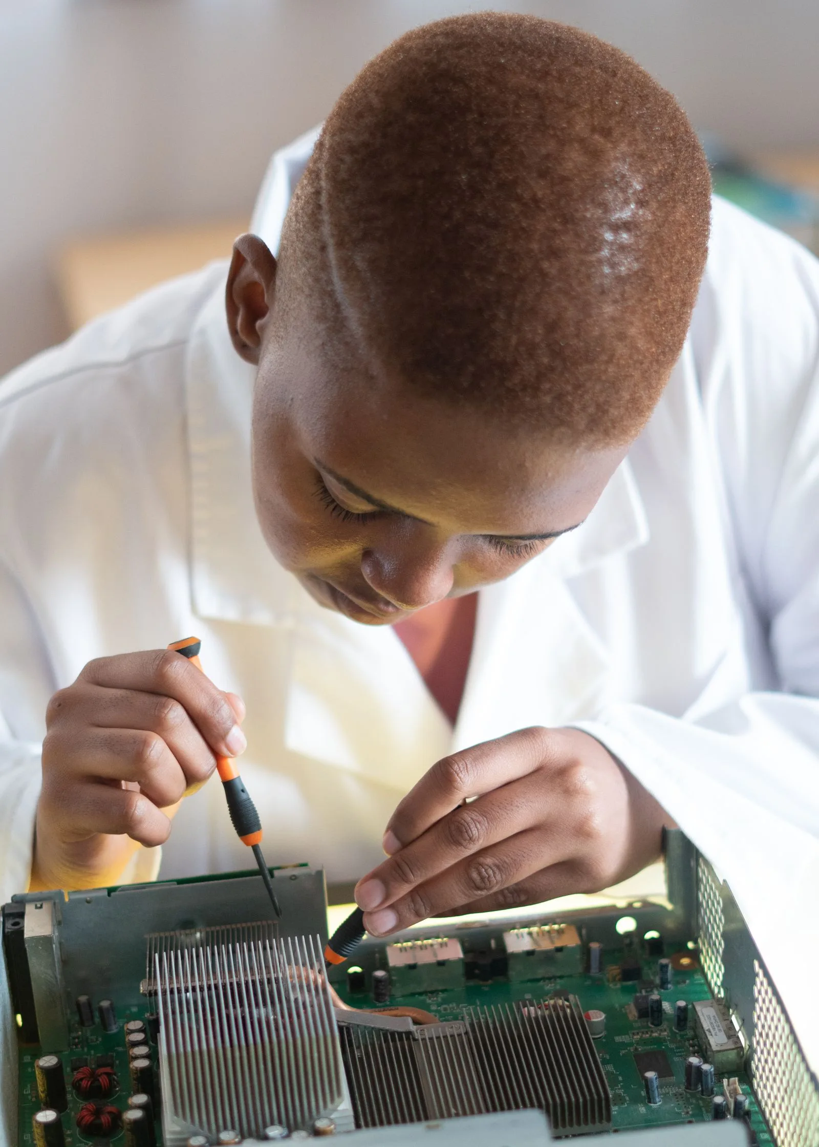 An engineer running a hardware diagnostic on a circuit board in a repair shop