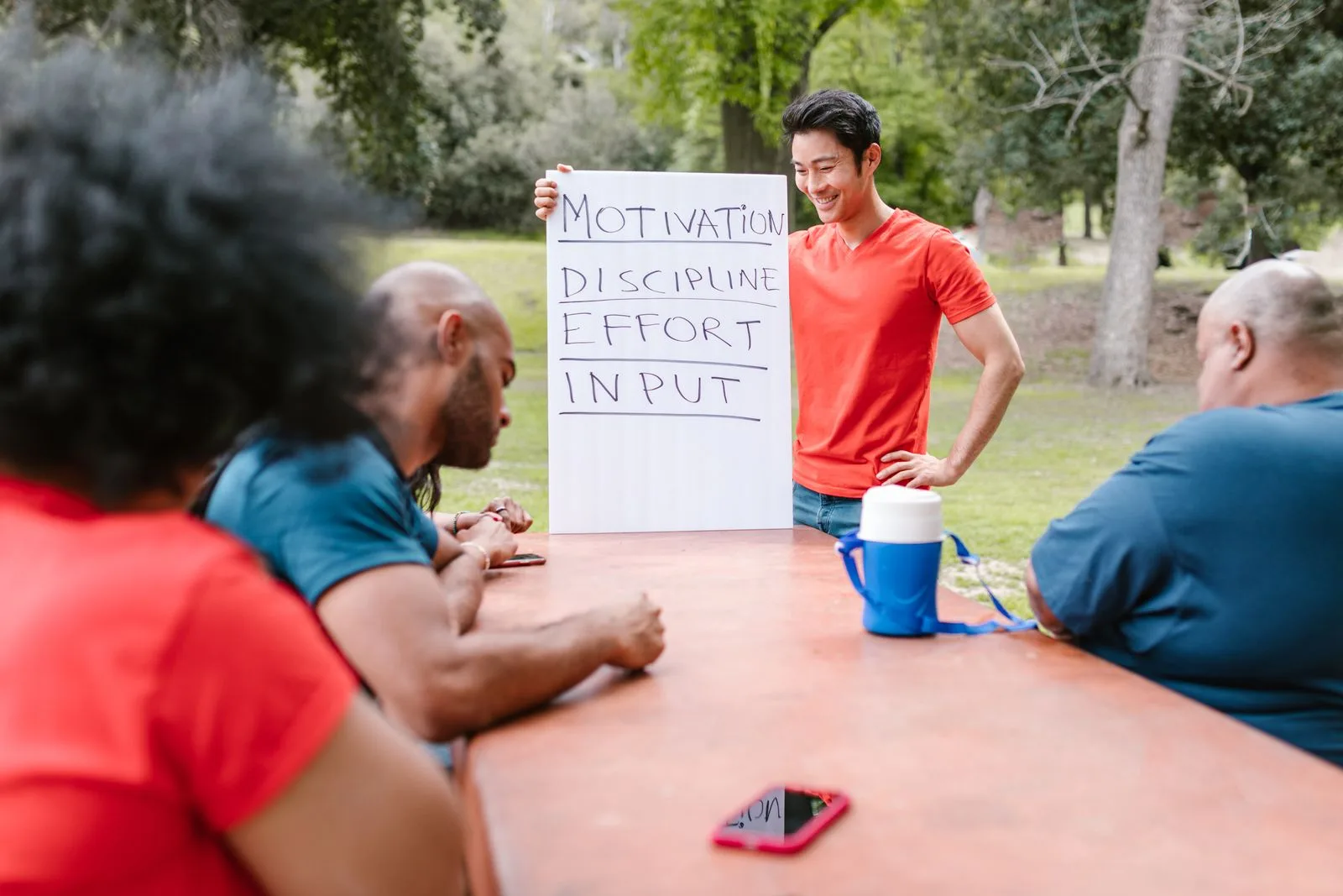 A group discussing goals around an outdoor table during a community training session