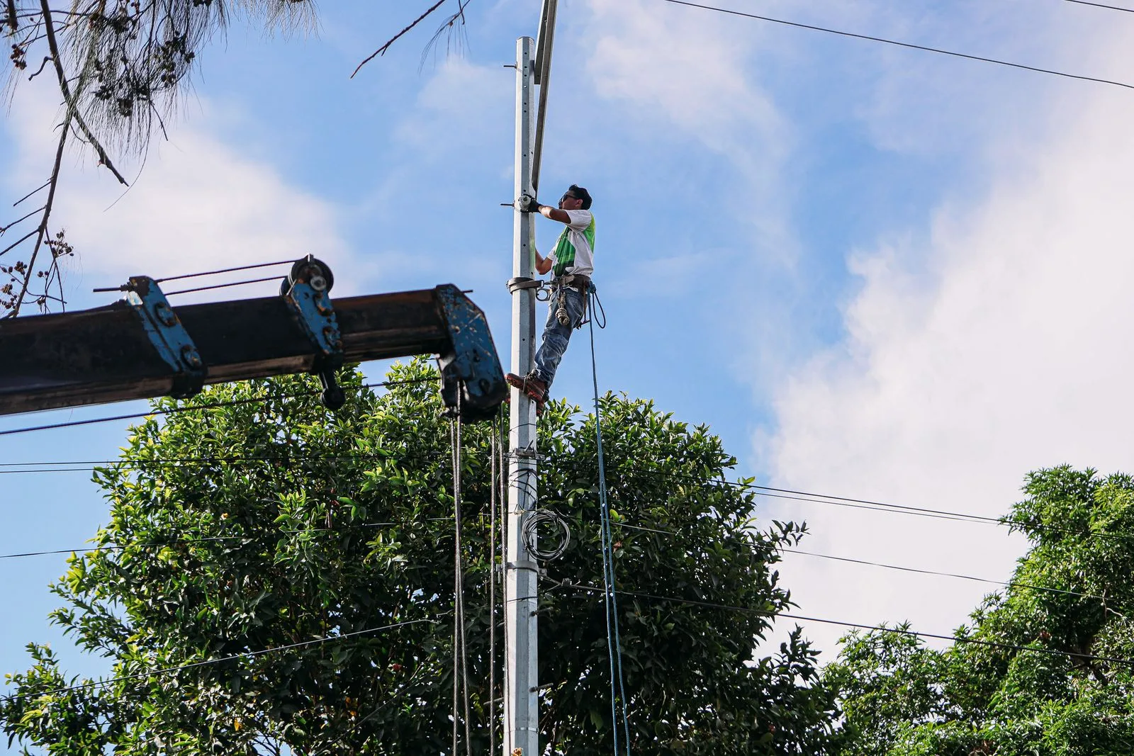 Utility worker climbing a pole for maintenance work